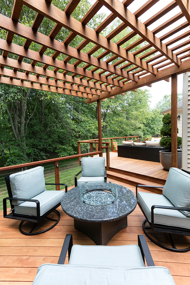 Inspiration for an expansive transitional backyard deck in Other with a fire feature and a pergola.