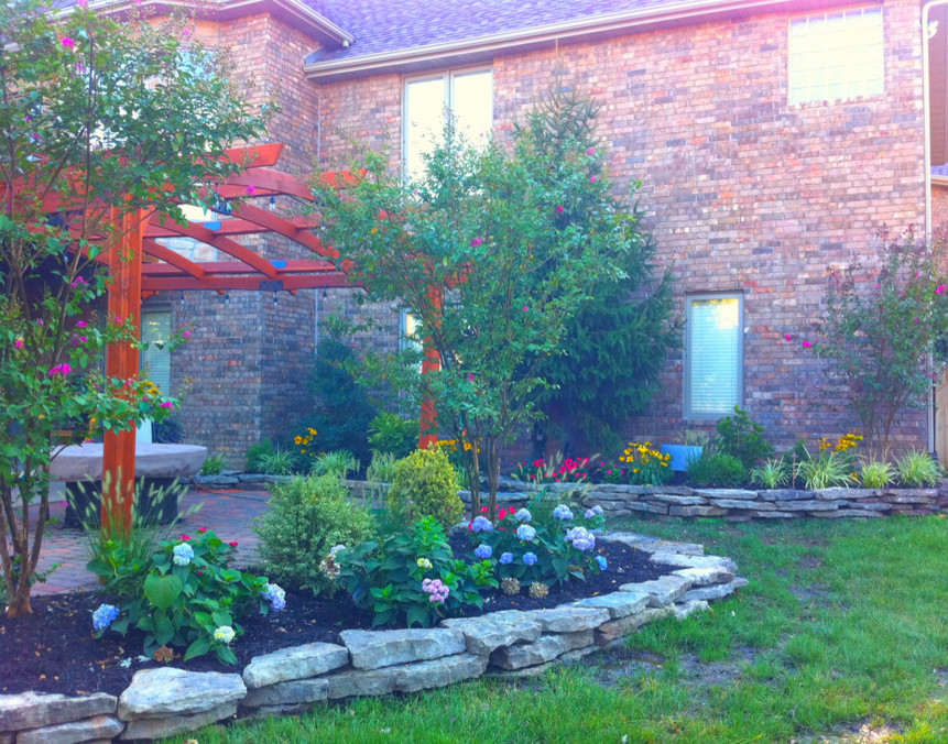 Design ideas for a mid-sized transitional full sun backyard landscaping for spring.
