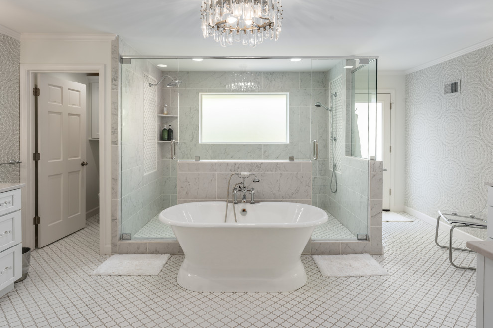 На фото: огромная главная, серо-белая ванная комната в стиле неоклассика (современная классика) с фасадами в стиле шейкер, белыми фасадами, отдельно стоящей ванной, двойным душем, инсталляцией, серыми стенами, полом из керамической плитки, столешницей из искусственного кварца, белым полом, душем с распашными дверями, белой столешницей, тумбой под две раковины, встроенной тумбой и обоями на стенах