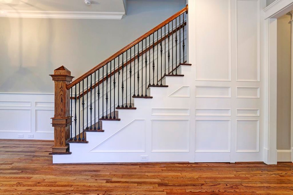 This is an example of a mid-sized traditional wood u-shaped staircase in Houston with painted wood risers and mixed railing.