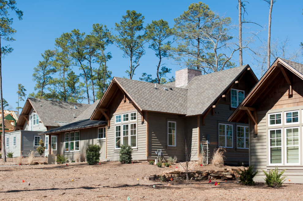 Photo of a mid-sized country two-storey house exterior in Houston with wood siding.