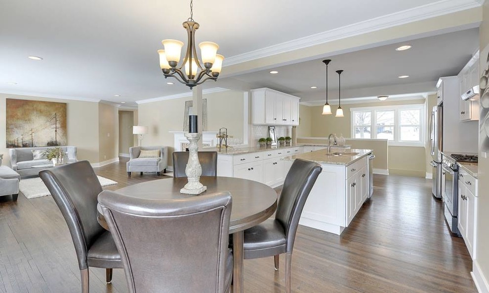 Example of a large transitional galley dark wood floor and brown floor open concept kitchen design in Minneapolis with an undermount sink, recessed-panel cabinets, white cabinets, stainless steel appliances and an island