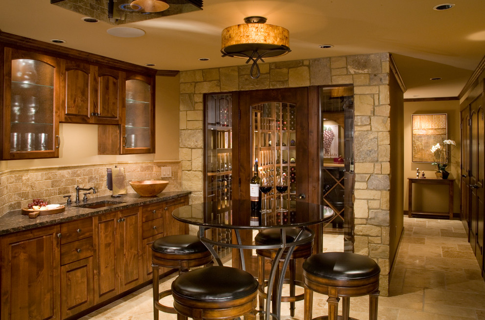 This is an example of a traditional single-wall wet bar in Seattle with an undermount sink, raised-panel cabinets, dark wood cabinets, beige splashback and beige floor.