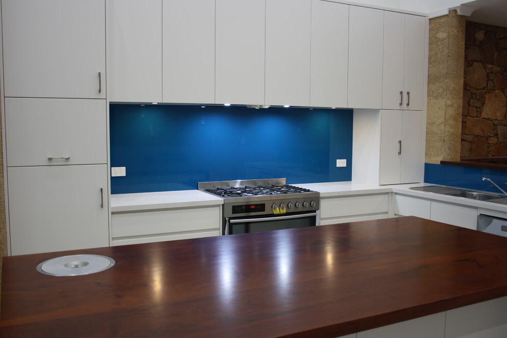 Contemporary kitchen with flat-panel cabinets, white cabinets, quartz benchtops, blue splashback and with island.