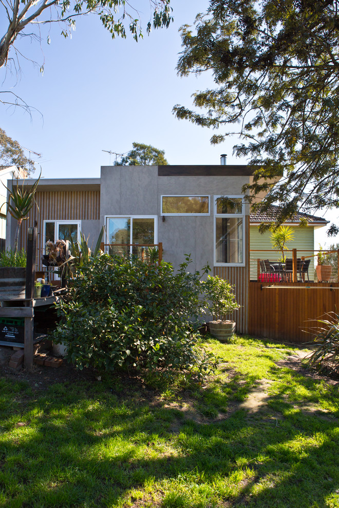 Photo of a mid-sized contemporary one-storey grey exterior in Melbourne with concrete fiberboard siding and a flat roof.