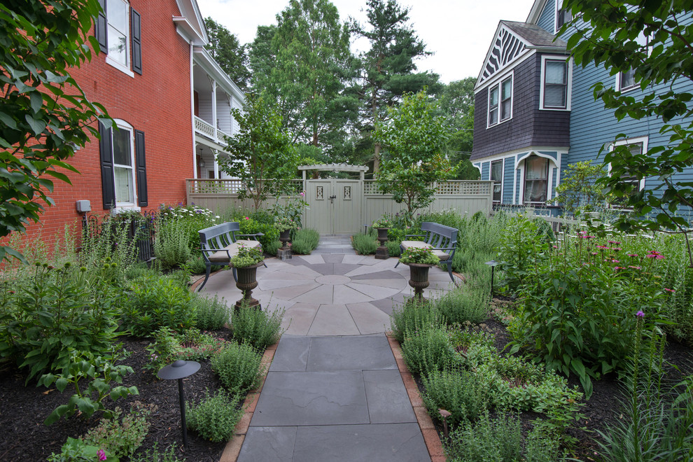This is an example of a traditional full sun garden in New York with a garden path.