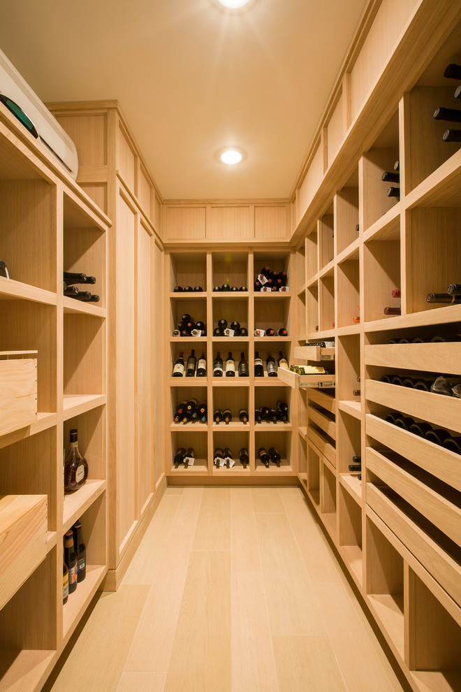 Photo of a small contemporary wine cellar in DC Metro with light hardwood floors and storage racks.