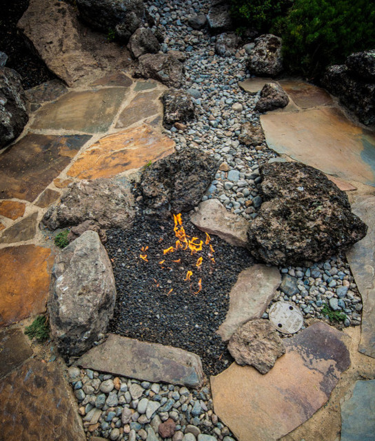 Design ideas for an expansive country backyard full sun garden in Other with a fire feature and natural stone pavers.