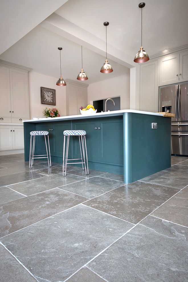 This is an example of a mid-sized country u-shaped kitchen in Other with limestone floors, with island and green floor.
