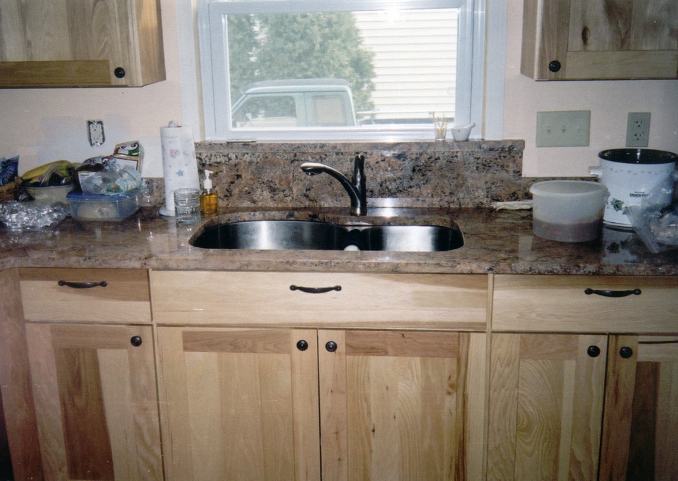 Inspiration for a small transitional galley ceramic tile and brown floor kitchen remodel with an undermount sink, recessed-panel cabinets, light wood cabinets, marble countertops, brown backsplash, marble backsplash, black appliances and brown countertops
