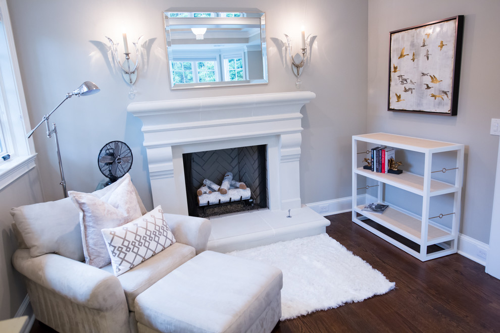 This is an example of a mid-sized transitional master bedroom in Atlanta with grey walls, medium hardwood floors, a standard fireplace and a wood fireplace surround.