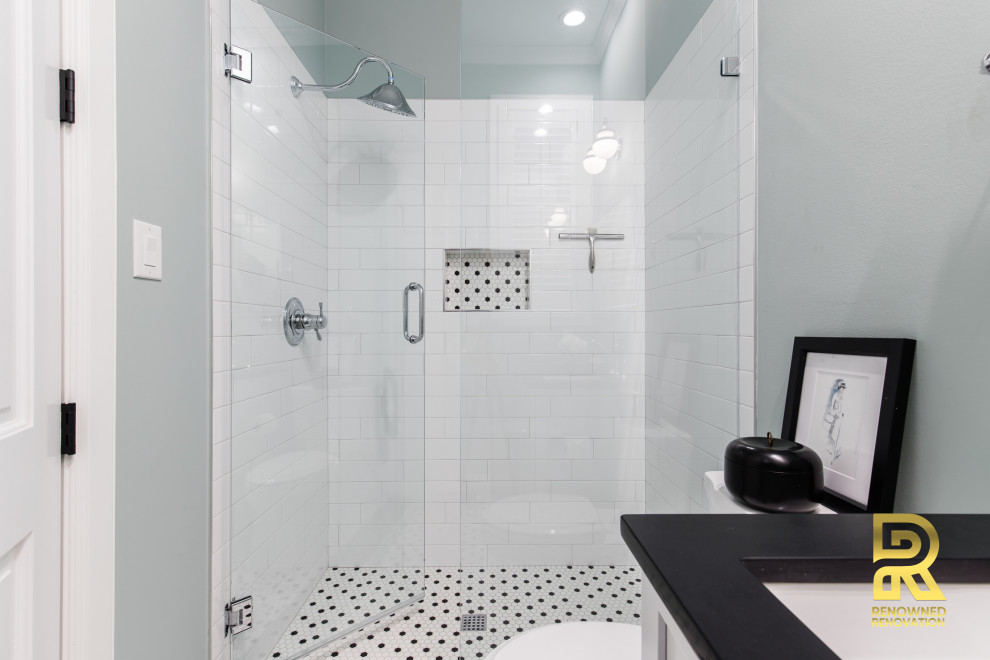 This is an example of a mid-sized transitional bathroom in Dallas with shaker cabinets, white cabinets, white tile, subway tile, mosaic tile floors, an undermount sink, engineered quartz benchtops, a hinged shower door, black benchtops, a single vanity and a built-in vanity.