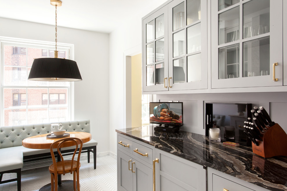 Design ideas for a traditional single-wall eat-in kitchen in New York with an undermount sink, flat-panel cabinets, grey cabinets, marble benchtops, grey splashback, stone tile splashback, white appliances, porcelain floors and no island.