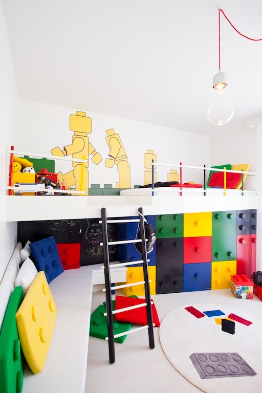 This is an example of a small modern gender-neutral kids' bedroom for kids 4-10 years old in Other with white walls and light hardwood floors.