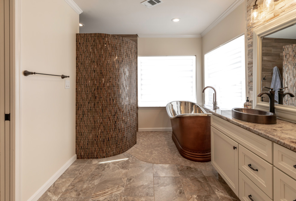Foto på ett mellanstort funkis vit en-suite badrum, med vita skåp, ett fristående badkar, en toalettstol med hel cisternkåpa, grå kakel, beige väggar, ett fristående handfat och med dusch som är öppen
