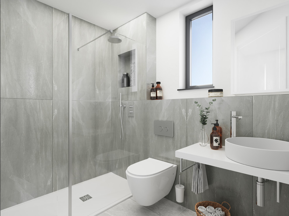 Photo of a contemporary 3/4 bathroom in London with a curbless shower, a wall-mount toilet, gray tile, white walls, a vessel sink, grey floor, an open shower and white benchtops.