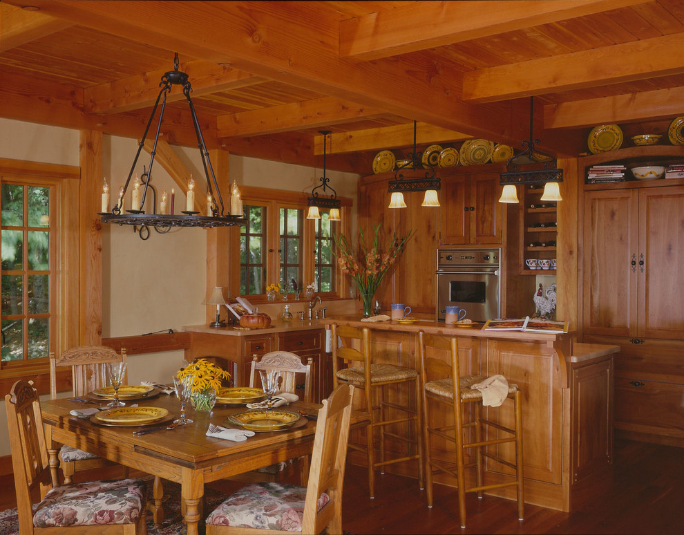 This is an example of a traditional l-shaped eat-in kitchen in Boston with a drop-in sink, beaded inset cabinets, medium wood cabinets, stainless steel appliances, dark hardwood floors and with island.