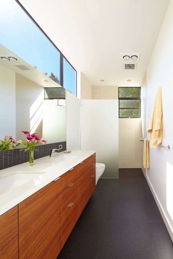 Inspiration for a contemporary master bathroom in San Francisco with an undermount sink, flat-panel cabinets, medium wood cabinets, engineered quartz benchtops, a curbless shower, a one-piece toilet, black tile and white walls.