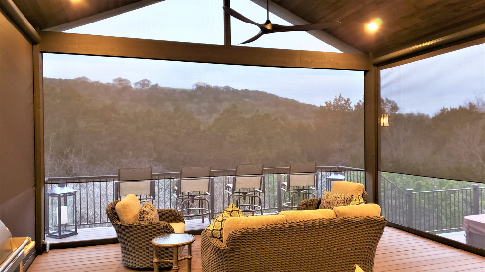 Large mountain style backyard second story metal railing deck photo in Austin with a roof extension