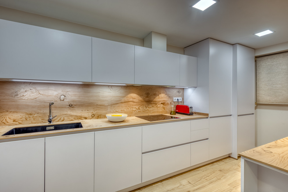 This is an example of a large modern kitchen in Barcelona with laminate floors.