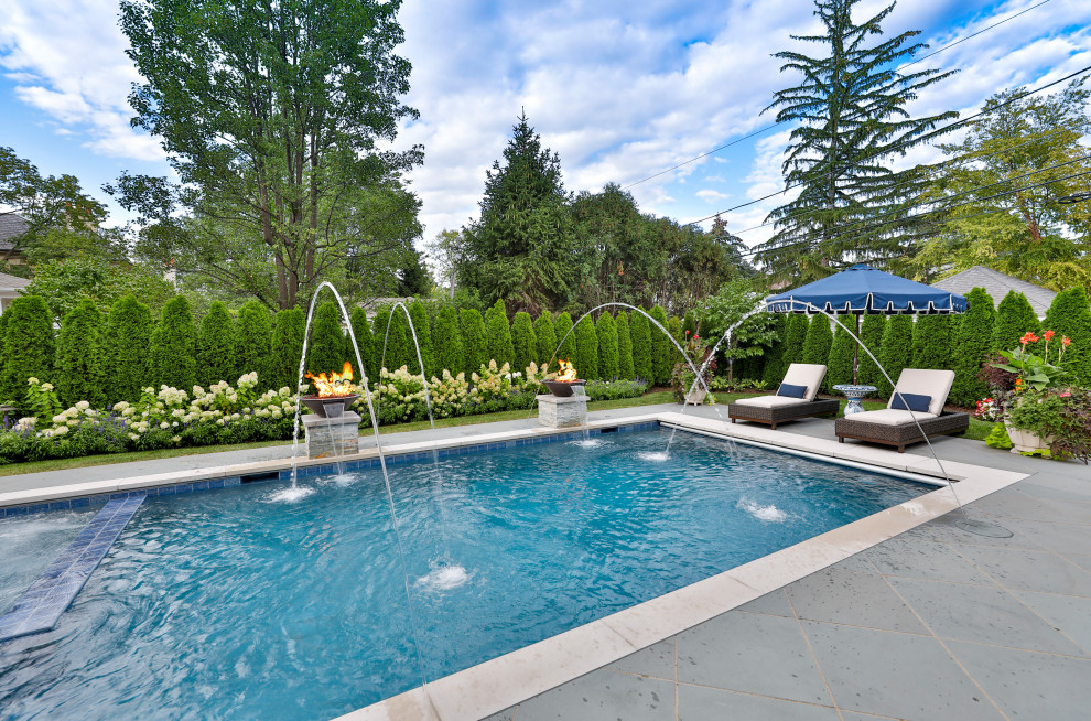 Photo of a medium sized traditional back private and rectangular lengths swimming pool in Chicago with natural stone paving.