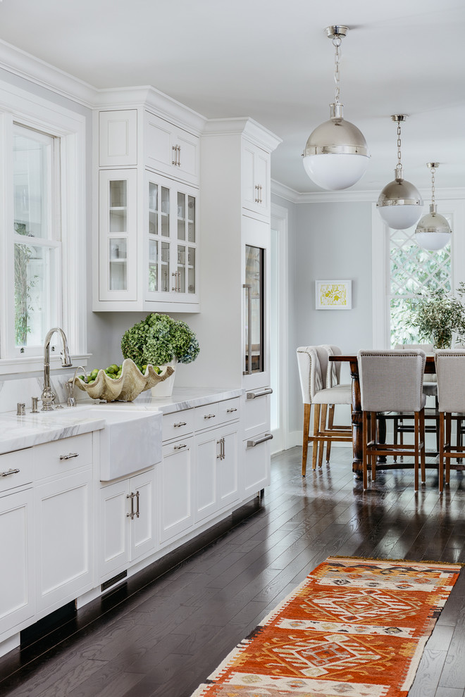 Design ideas for a mid-sized traditional eat-in kitchen in San Francisco with white cabinets, dark hardwood floors, brown floor, a farmhouse sink and recessed-panel cabinets.