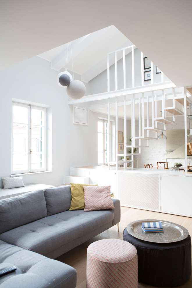 Scandinavian open concept living room in Rome with light hardwood floors.