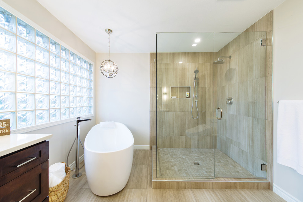 Photo of a large country master bathroom in Vancouver with shaker cabinets, brown cabinets, a freestanding tub, a corner shower, a bidet, brown tile, porcelain tile, beige walls, porcelain floors, an undermount sink and marble benchtops.
