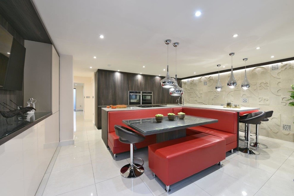 Contemporary galley open plan kitchen in Manchester with an undermount sink, flat-panel cabinets, dark wood cabinets, solid surface benchtops, stainless steel appliances, porcelain floors and with island.
