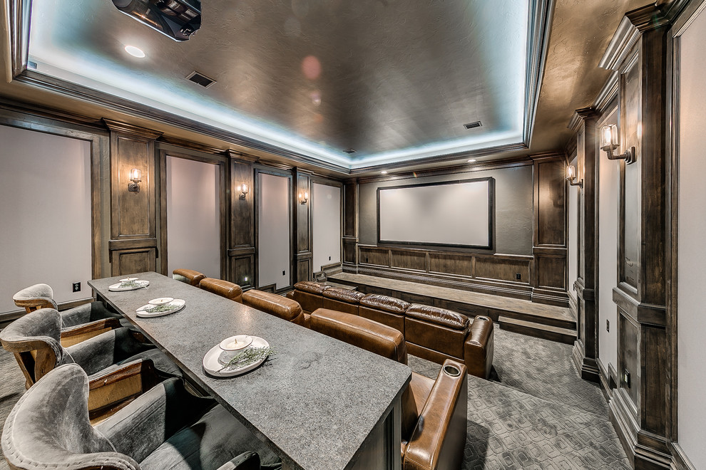 This is an example of a large country enclosed home theatre in Oklahoma City with grey walls, carpet, grey floor and a projector screen.