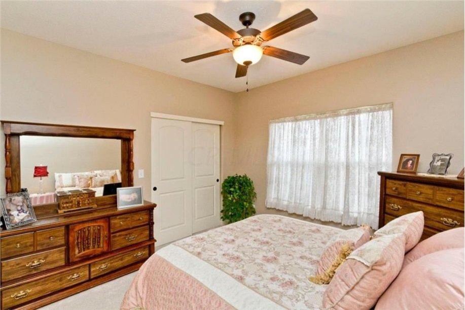 Large traditional bedroom in Columbus with beige walls, carpet and no fireplace.