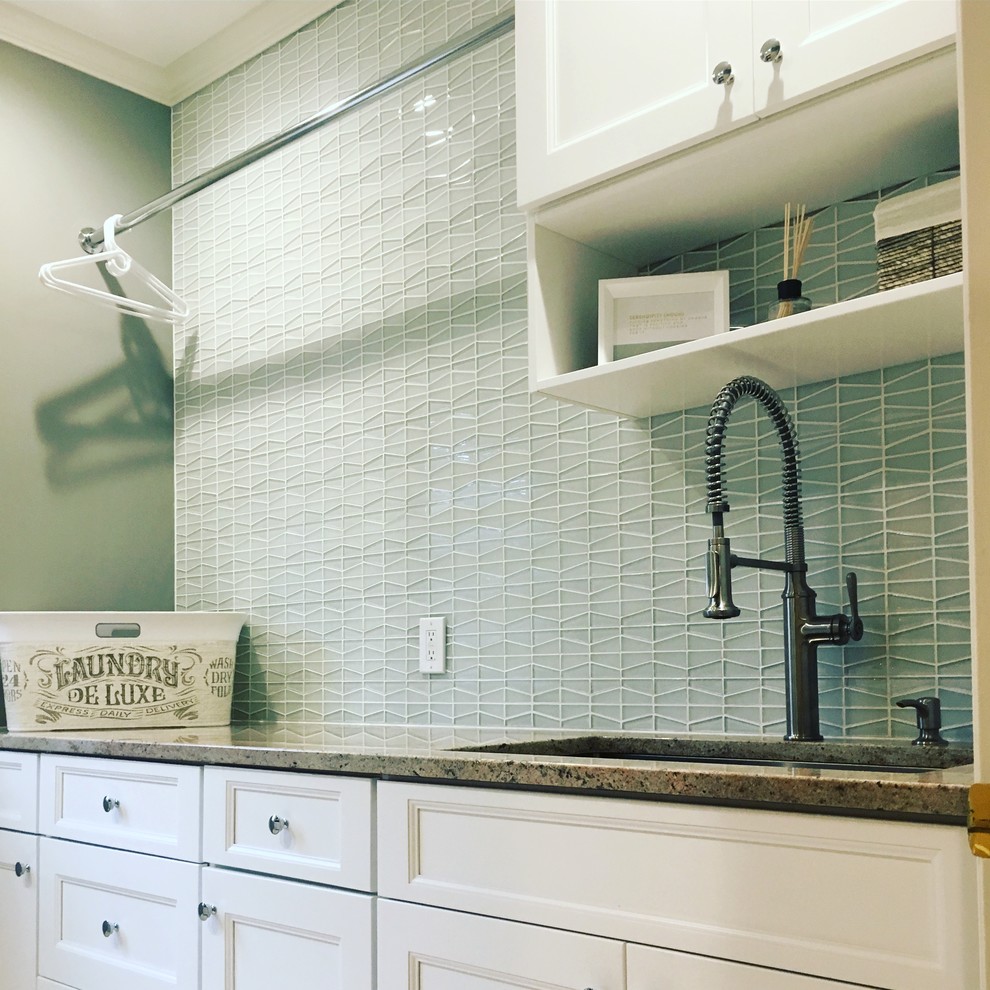 Photo of a large contemporary galley dedicated laundry room in Cleveland with an undermount sink, recessed-panel cabinets, white cabinets, granite benchtops, grey walls, porcelain floors and a side-by-side washer and dryer.