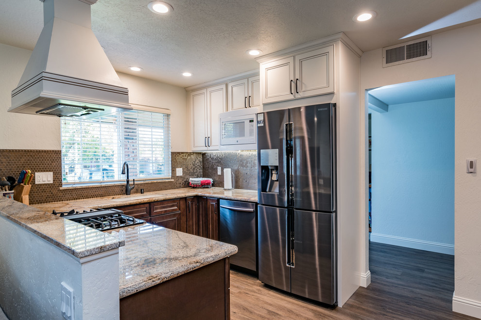 Mid-sized transitional u-shaped medium tone wood floor and brown floor eat-in kitchen photo with an undermount sink, recessed-panel cabinets, white cabinets, granite countertops, brown backsplash, mosaic tile backsplash, stainless steel appliances and no island