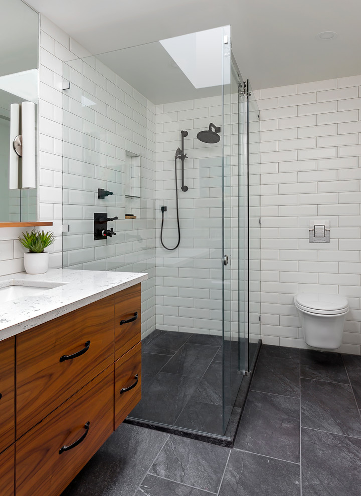 Inspiration for a contemporary 3/4 bathroom in Vancouver with flat-panel cabinets, medium wood cabinets, white tile, subway tile, an undermount sink, green floor, a hinged shower door and a wall-mount toilet.