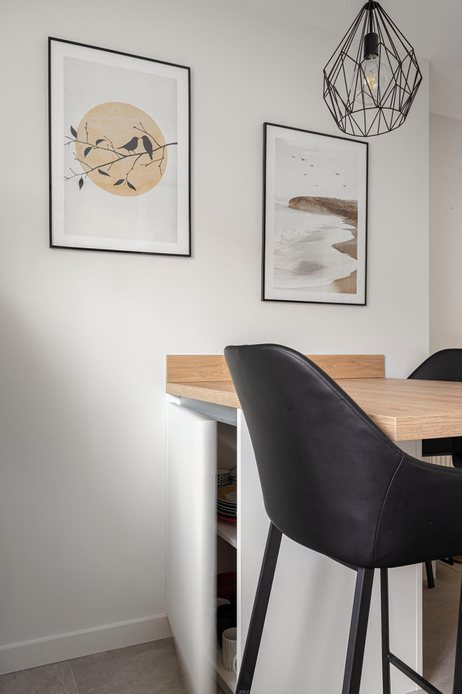Réalisation d'une cuisine blanche et bois nordique en L fermée et de taille moyenne avec un placard à porte affleurante, des portes de placard blanches, un plan de travail en stratifié, une crédence marron, un sol en carrelage de céramique, aucun îlot, un sol gris et un plan de travail gris.
