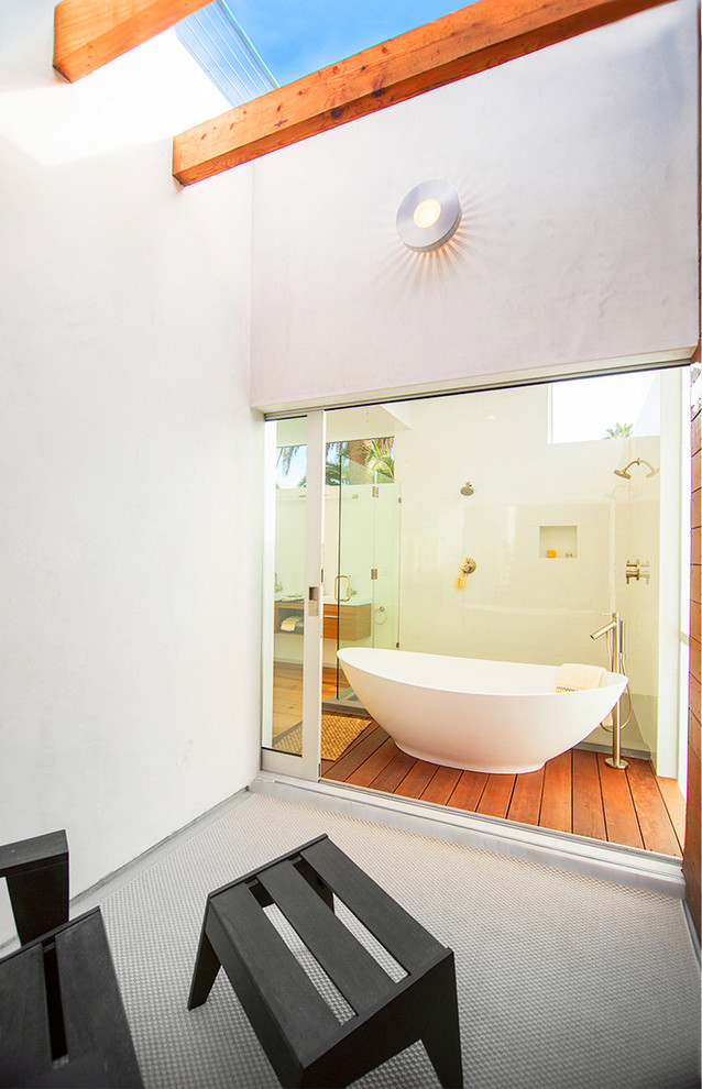 This is an example of a contemporary master bathroom in Los Angeles with a freestanding tub, a double shower, a vessel sink, flat-panel cabinets, medium wood cabinets, white tile, ceramic tile, white walls and medium hardwood floors.