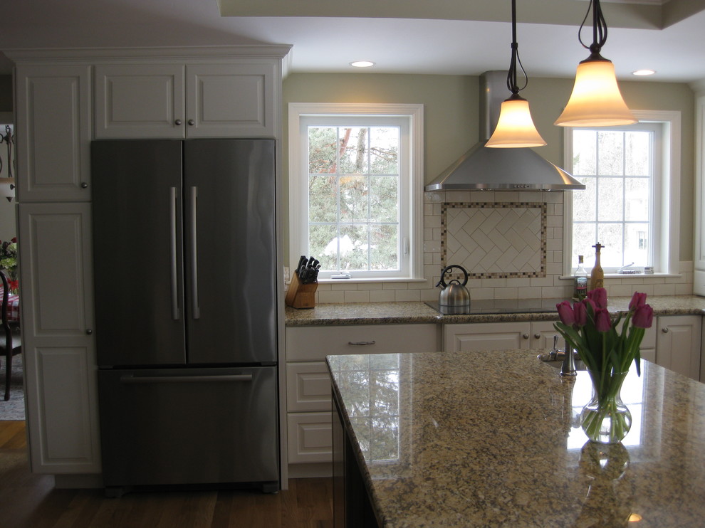 Eat-in kitchen - transitional u-shaped medium tone wood floor eat-in kitchen idea in Boston with an undermount sink, raised-panel cabinets, white cabinets, granite countertops, white backsplash, ceramic backsplash, stainless steel appliances, an island and beige countertops