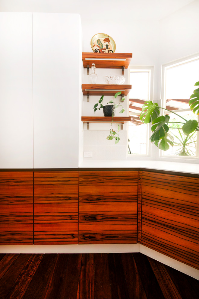 Moderne Wohnküche mit weißen Schränken, Rückwand aus Porzellanfliesen, dunklem Holzboden, Kücheninsel, braunem Boden und weißer Arbeitsplatte in Perth