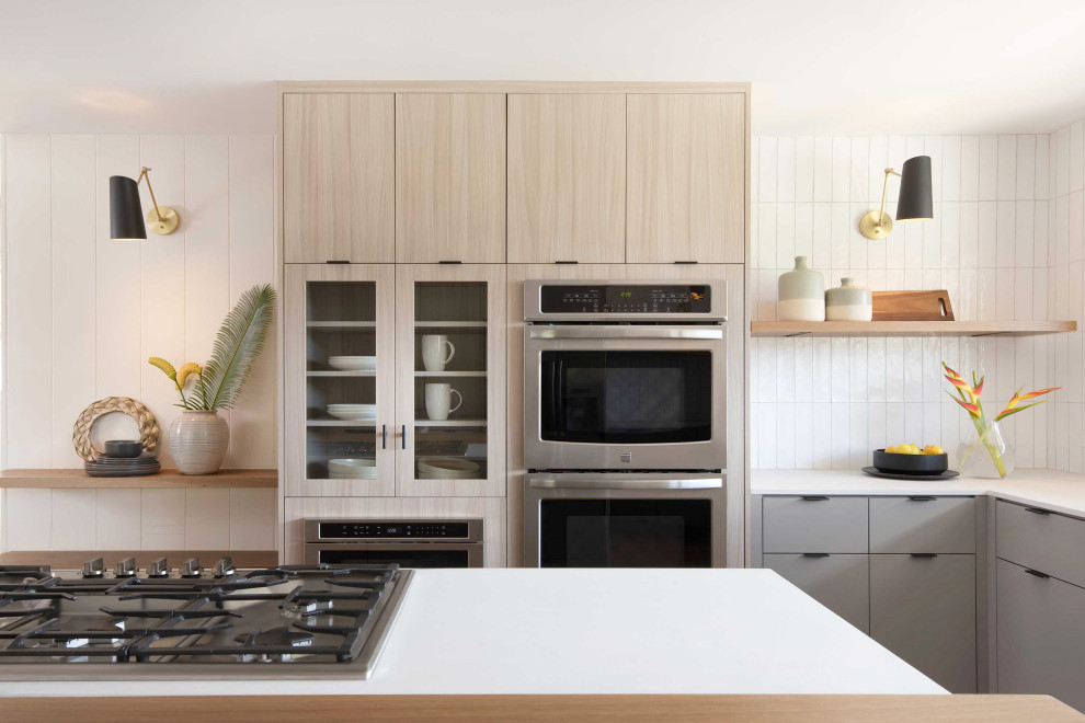 Große Moderne Wohnküche in L-Form mit flächenbündigen Schrankfronten, hellen Holzschränken, Küchenrückwand in Weiß, Kücheninsel und weißer Arbeitsplatte in Hawaii