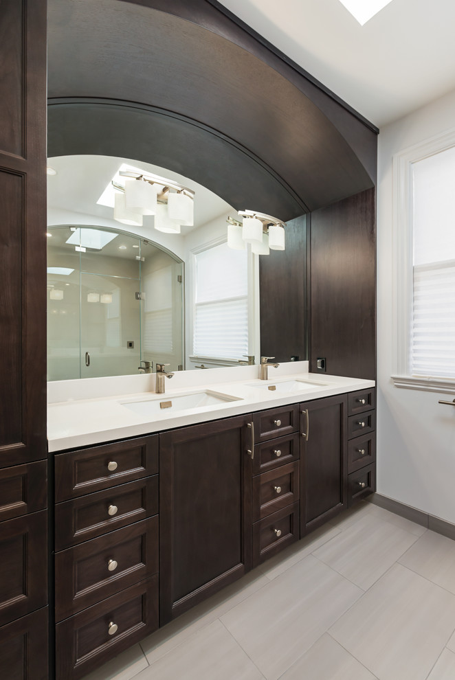 Photo of a large traditional master bathroom in San Francisco with an undermount sink, recessed-panel cabinets, dark wood cabinets, white walls, porcelain floors and engineered quartz benchtops.