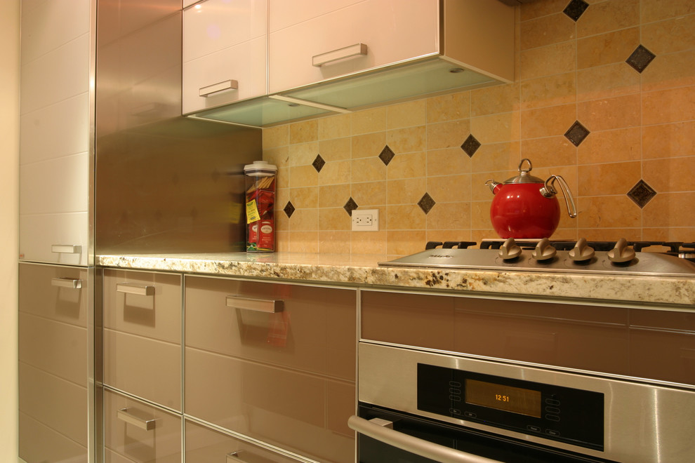 Photo of a small modern galley separate kitchen in New York with glass-front cabinets, white cabinets, ceramic splashback, stainless steel appliances, ceramic floors, no island, an undermount sink, granite benchtops and beige splashback.