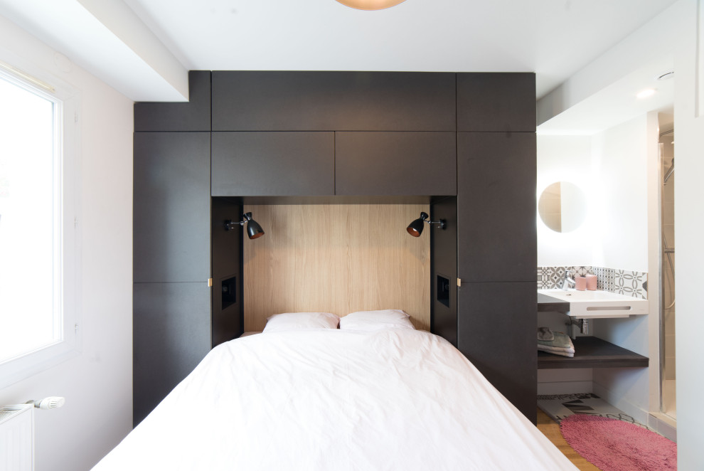 Ejemplo de habitación de invitados contemporánea pequeña con paredes blancas y suelo de madera clara