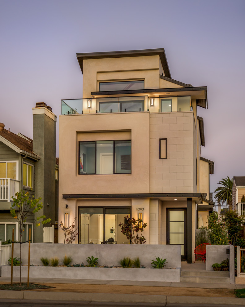 Inspiration for a contemporary three-storey beige house exterior in Orange County.