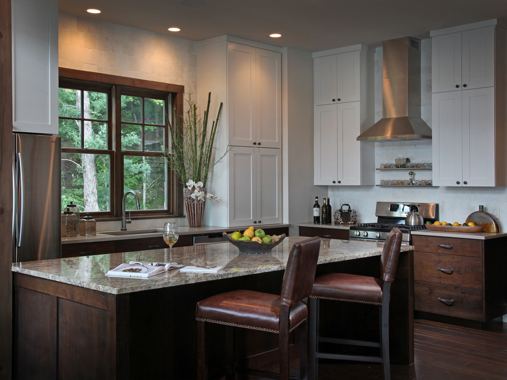 Photo of a mid-sized country l-shaped eat-in kitchen in Atlanta with an undermount sink, shaker cabinets, white cabinets, marble benchtops, beige splashback, porcelain splashback, stainless steel appliances, dark hardwood floors and with island.