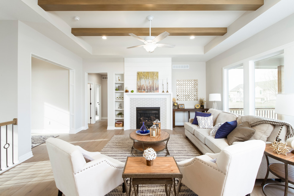 Design ideas for a transitional formal living room in Wichita with beige walls, light hardwood floors, a standard fireplace, a tile fireplace surround and no tv.