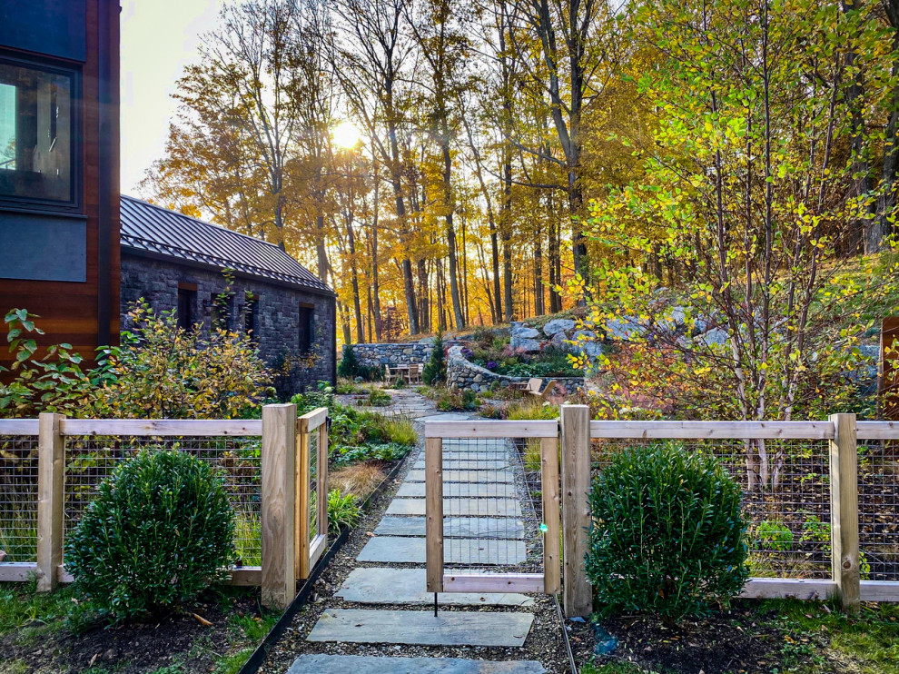 Inspiration for a large contemporary front yard partial sun garden in New York with with a gate, gravel and a wood fence.
