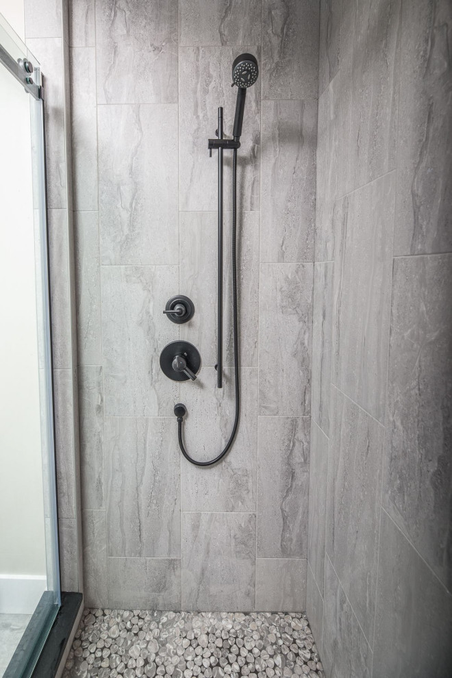 Inspiration for a large transitional gray tile and ceramic tile ceramic tile and gray floor freestanding bathtub remodel with a two-piece toilet, beige walls and a hinged shower door