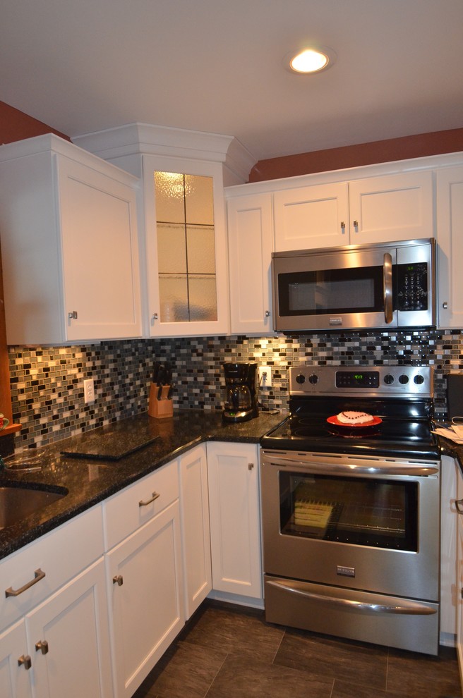 Inspiration for a mid-sized transitional u-shaped porcelain tile and brown floor enclosed kitchen remodel with an undermount sink, shaker cabinets, white cabinets, quartz countertops, multicolored backsplash, mosaic tile backsplash, stainless steel appliances and no island