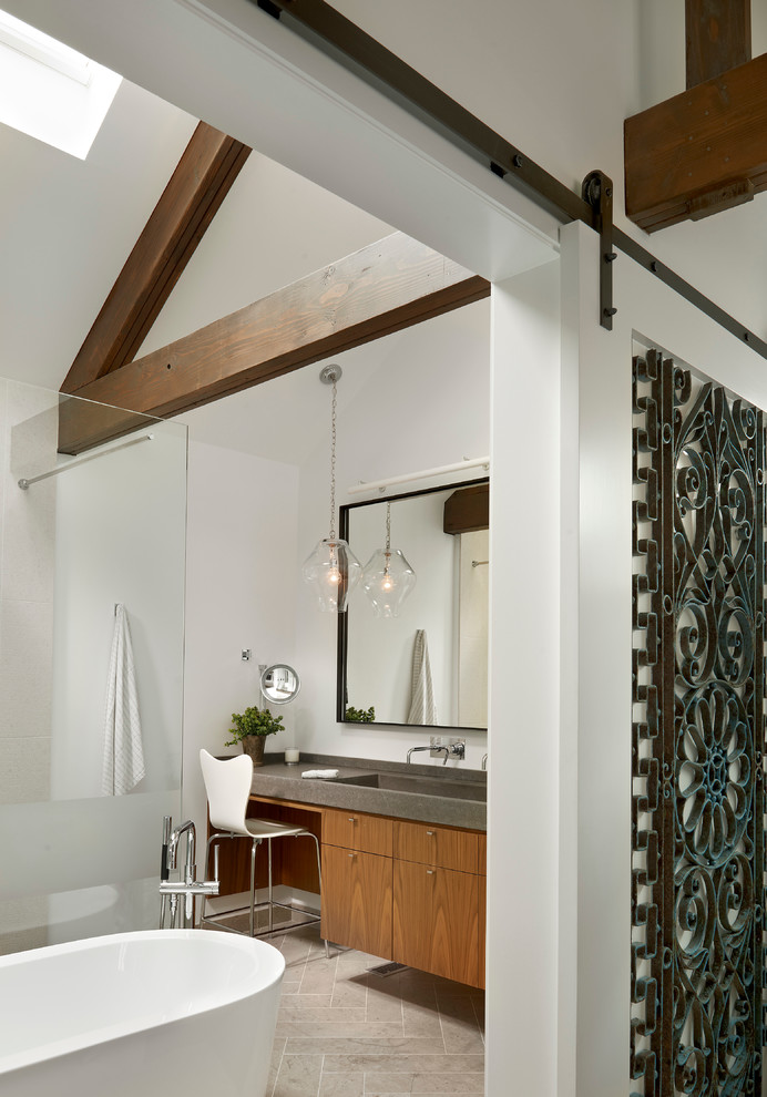 Design ideas for a mid-sized transitional master bathroom in Chicago with an integrated sink, flat-panel cabinets, medium wood cabinets, concrete benchtops, a freestanding tub, an open shower, white walls, limestone floors and an open shower.