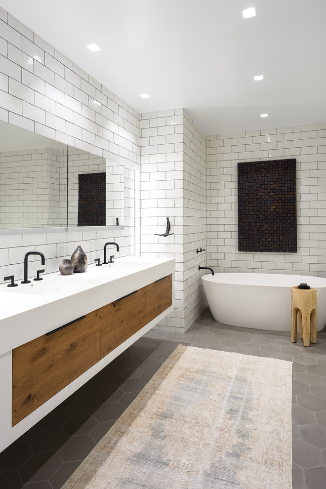 Mid-sized transitional master bathroom in Chicago with flat-panel cabinets, medium wood cabinets, a freestanding tub, white tile, subway tile, an integrated sink, grey floor, white benchtops, an alcove shower, white walls and cement tiles.